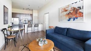 Una sala de estar con un sofá azul y una cocina. en Downtown San Antonio Apartments by Landing, en San Antonio