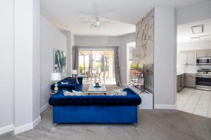 Una sala de estar con un sofá azul y una cocina. en Silver Lining - Luxury for 10, en Haines City 39 fotos más