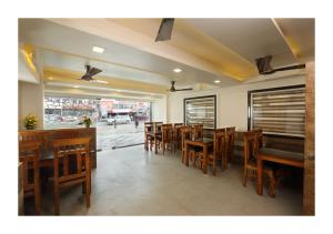 a dining room with wooden tables and chairs at Hotel Kochi Caprice in Cochin