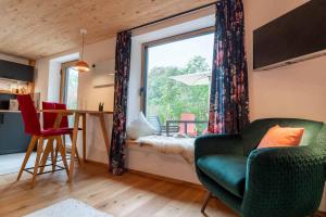 a living room with a green couch and a window at Mächlerhof in Stötten am Auerberg