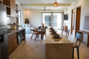 a kitchen and living room with a table and chairs at Otonomus Tulum in Tulum