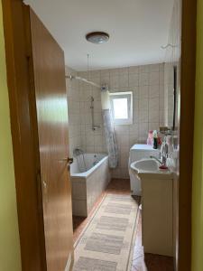 a bathroom with a tub and a toilet and a sink at Domek Krysi in Smorczewo