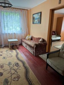 a living room with a couch and a window at Domek Krysi in Smorczewo