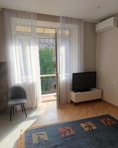 a living room with a television and a chair at Sweet Home Mergelyan in Yerevan