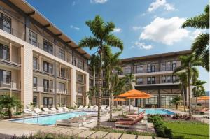une vue extérieure d'un bâtiment avec piscine et palmiers dans l'établissement Historic Springfield Apartments by Landing, à Jacksonville