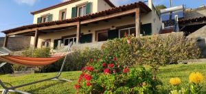 ein Haus mit einer Hängematte vor einem Garten in der Unterkunft Casa da Ovelha I Madeira in Fajã da Ovelha + 13 Fotos