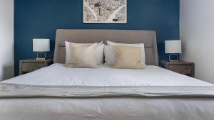 a bedroom with a white bed with two night stands at Landing at Echo Trail Apartments - Tulsa in Tulsa +35 photos