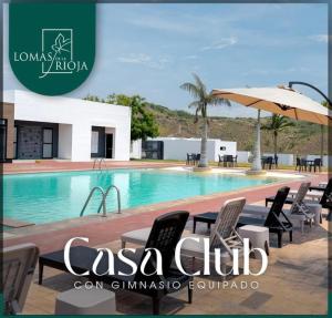 a swimming pool with chairs and an umbrella at Casa en Riviera Veracruzana in Guadalupe