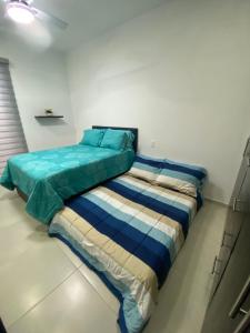 a bedroom with a bed with blue and white sheets at Casa en Riviera Veracruzana in Guadalupe +18 photos