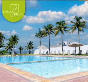 a large swimming pool with palm trees and chairs at Casa en Riviera Veracruzana in Guadalupe