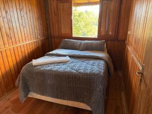 a small bed in a room with a window at CABANAS BELVEDERE SERRA DO RiO DO RASTRO in Louro Müller