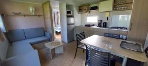 una piccola cucina con tavolo e una sala da pranzo di Mobil home 6 pers, dans Camping 4 Etoiles, 3ch, grande terrasse couverte a Pont-Aven