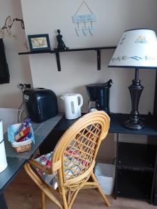a desk with a chair and a table with a lamp at Owls Roost in Stowmarket