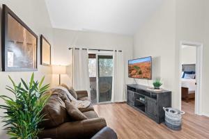 a living room with a couch and a flat screen tv at Hikers Hideaway - Cozy Resort Condo with Pool & More in St. George