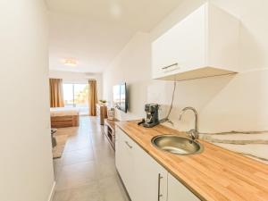 a kitchen with white cabinets and a sink at Jandia Sunrise, Your Sweet Holiday Home in Morro del Jable +33 photos