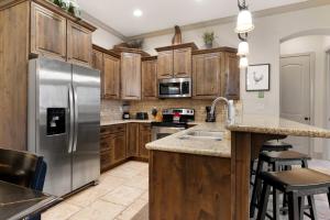 a kitchen with wooden cabinets and a stainless steel refrigerator at Utahs Beauty with Desert & Mtn Views in Washington +33 photos