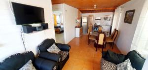 a living room with a couch and a dining room at Cabañas Jardín Alto in Pichilemu