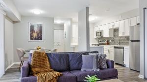 a living room with a purple couch and a kitchen at Landing at Fountain Parc - Indianapolis in Indianapolis