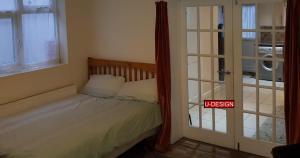 a bedroom with a bed and a door with a sign at Parkside Studio in Luton