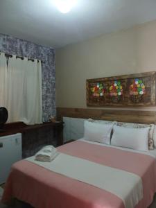 a bedroom with two beds and a window at Pouso C&L in Tiradentes