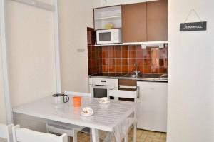 a small kitchen with a table and a microwave at Joli studio cabine à 500m plages in Cavalaire-sur-Mer