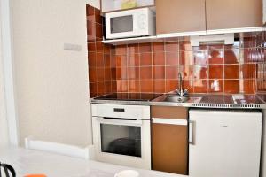 a kitchen with a sink and a microwave at Joli studio cabine à 500m plages in Cavalaire-sur-Mer
