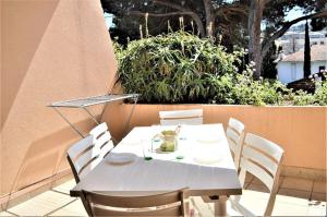 a white table and chairs on a patio at Joli studio cabine à 500m plages in Cavalaire-sur-Mer +1 photo