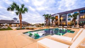a swimming pool with lounge chairs and a resort at Landing Apartments Austin - Pflugerville in Pflugerville