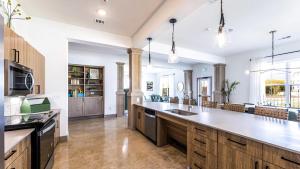 a large kitchen with wooden cabinets and a large island at Landing Apartments Austin - Pflugerville in Pflugerville