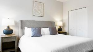 a bedroom with a large white bed with two lamps at Landing at The Landing - Indianapolis in Indianapolis +16 photos