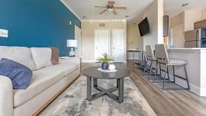 a living room with a couch and a table and a kitchen at Landing Apartments - Summerville in Summerville