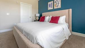 a bedroom with a large white bed with red pillows at Landing Apartments - Summerville in Summerville +26 photos