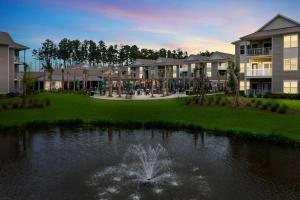 a rendering of a resort with a fountain in a pond at Landing Apartments - Summerville in Summerville