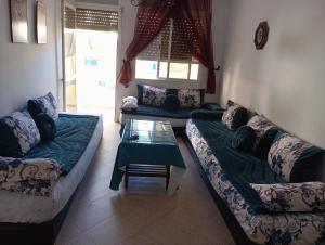 a living room with two couches and a table at Arenabeach in Martil +51 photos