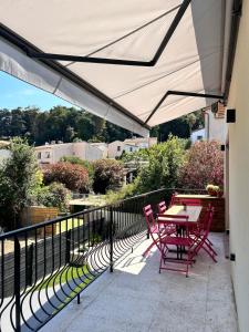 Un patio con una mesa y sillas en un balcón. en Attic Nest Intimité - confort en coliving, en Cagnes-sur-Mer