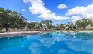 a swimming pool with a blue sky and clouds at Landing Fort Myers - Forestwood in Fort Myers