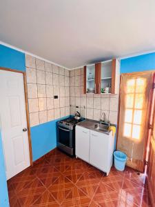 a small kitchen with a sink and a stove at HOSTAL APANANTOR 1 in San Pedro de Atacama +7 photos