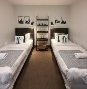 ラック・シュペリュールにあるChalet Inukshuk Luxury Log Cabin with Spa Lake View and Club Access near Mont Tremblantのベッド2台が備わる客室です。
