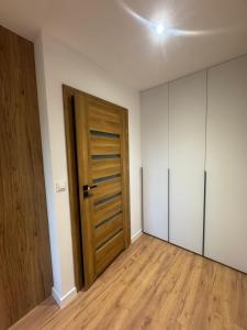 an empty room with a wooden door and white walls at Apartament Oli in Ostróda