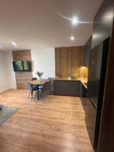 a kitchen and dining room with a table and chairs at Apartament Oli in Ostróda