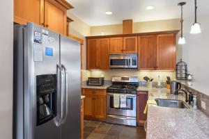a kitchen with stainless steel appliances and wooden cabinets at Sunny Woods Acres - Near Golf & Adventure Park in Tahoe Vista