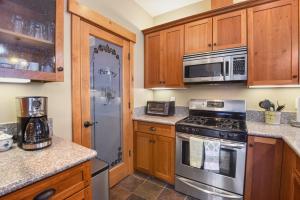 a kitchen with stainless steel appliances and wooden cabinets at Sunny Woods Acres - Near Golf & Adventure Park in Tahoe Vista +28 photos