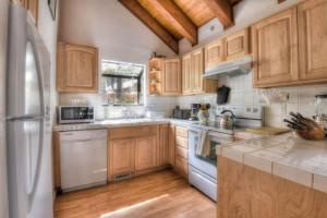 a kitchen with wooden cabinets and white appliances at Glacier Forest Getaway HOA Access in Truckee