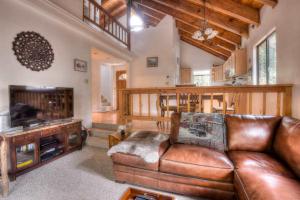 a living room with a leather couch and a television at Glacier Forest Getaway HOA Access in Truckee