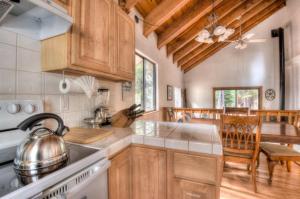 a kitchen with wooden cabinets and a stove top oven at Glacier Forest Getaway HOA Access in Truckee +23 photos