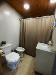 a bathroom with a toilet and a sink and a shower at Ruca Caihuin Sweet Home in Chapadmalal +25 photos