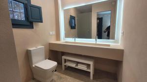 a bathroom with a toilet and a sink with a mirror at El Garrotal de Medina in Carmona +20 photos