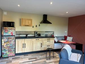 una cucina con un frigorifero e un tavolo in una stanza di Le Hangar - Studio esprit industriel a Pont-Rémy