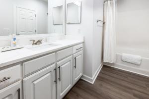 a white bathroom with two sinks and a mirror at Landing Bellingham Park - Wilmington in Wilmington +37 photos