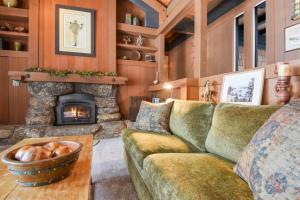 Una sala de estar con un sofá y una chimenea. en Joy on the River Stunning Waterfront Home for 10, en Olympic Valley